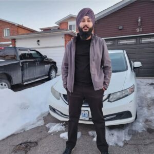 A guy standing in front of a car